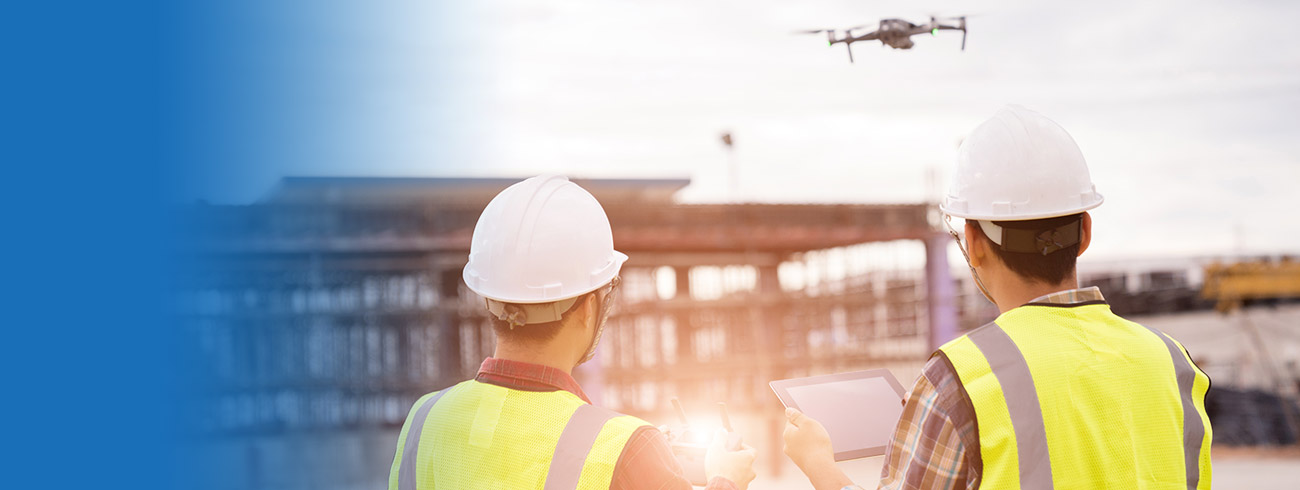 Two engineers with a drone on a building site documenting construction supervision.